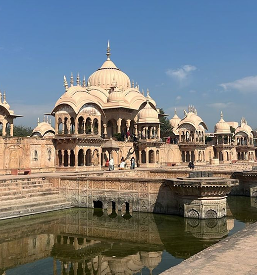 Historic stone chhatris and reflecting water of Kusum Sarovar in Braj